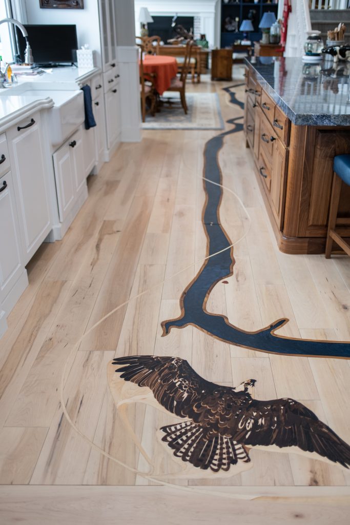The Fight is a custom hardwood art floor project featuring a Bald Eagle and Osprey Eagle entangled in a fight over the Spokane River. 